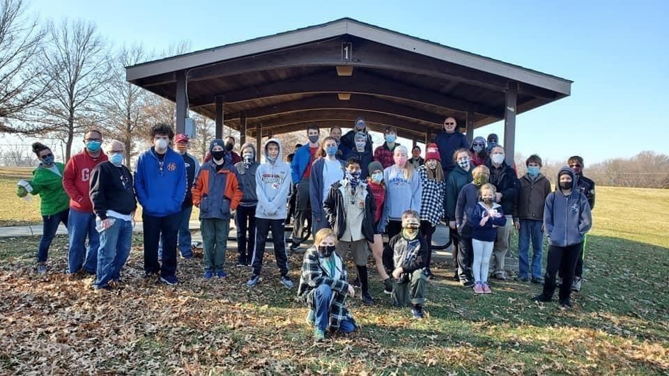 Photo of individuals standing in front of a park shelter